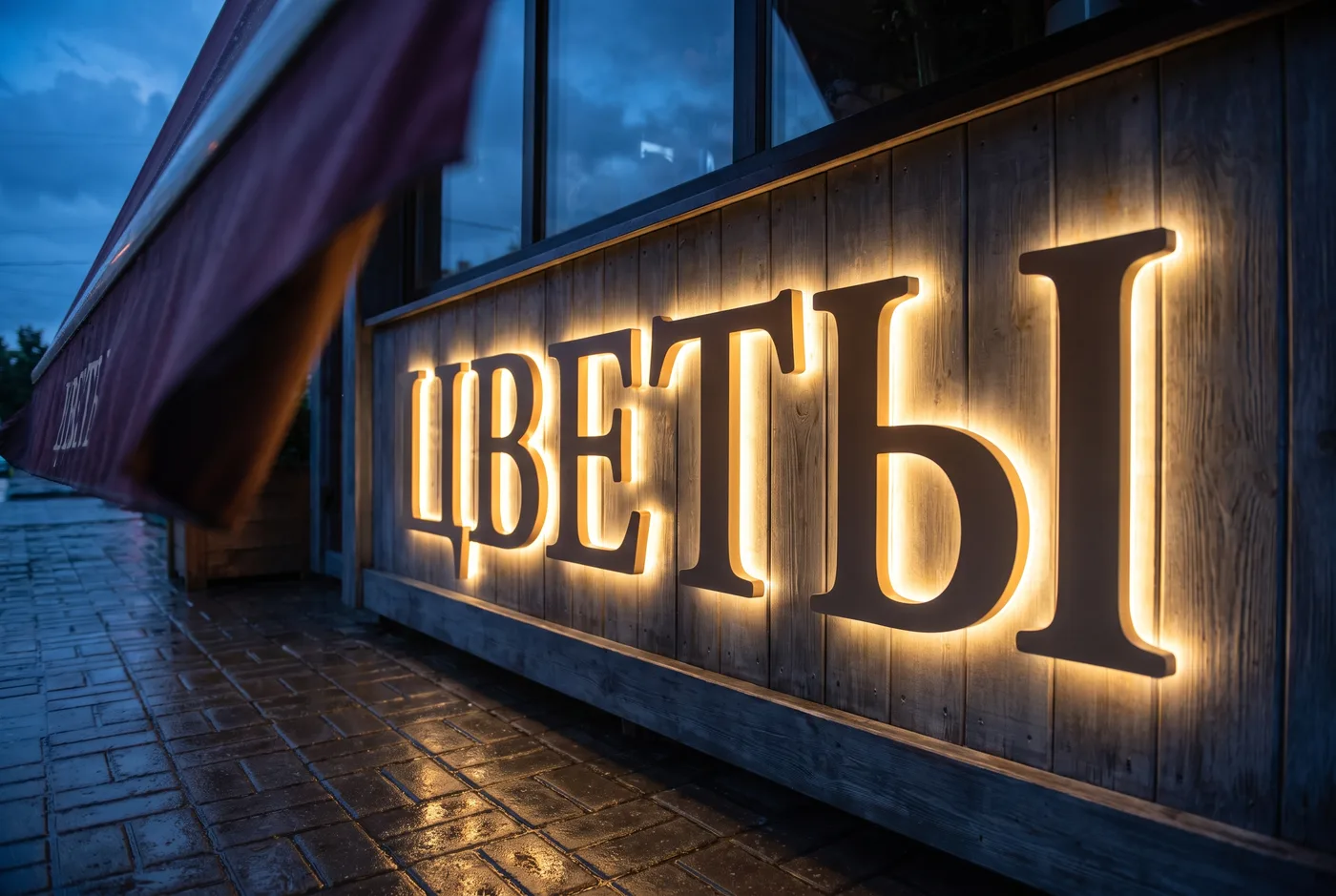Подсвеченная вывеска в сумерках Подсвеченная вывеска в сумерках — фасад цветочного магазина крупным планом