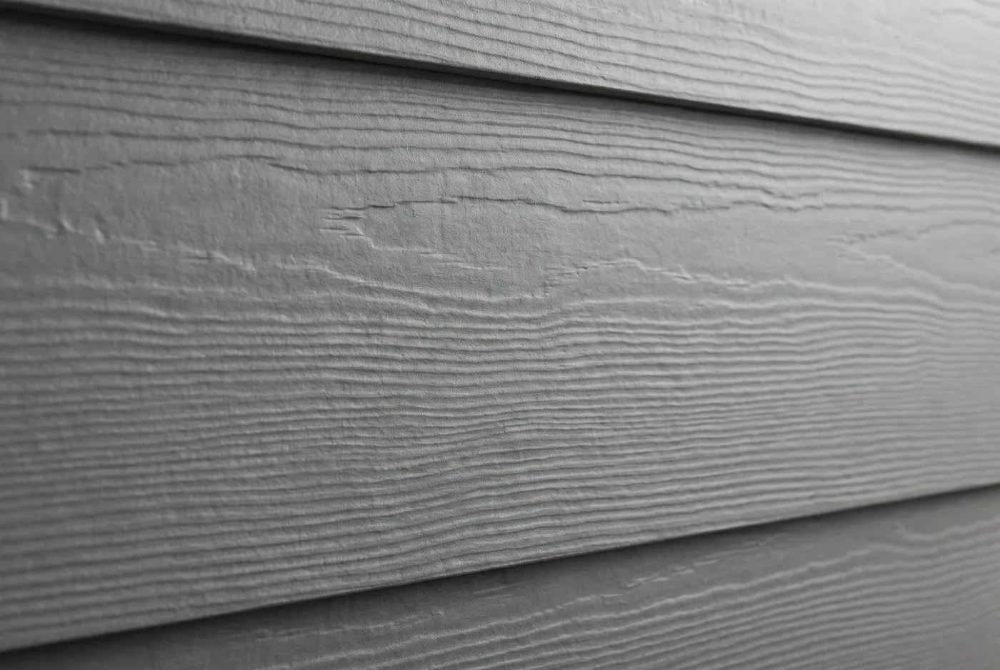 Фиброцементный сайдинг вблизи Фиброцементный сайдинг вблизи — отделка фасада каркасного дома крупным планом